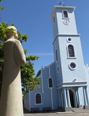 Estátua do Pe. Tavares e ao fundo Igreja Matriz